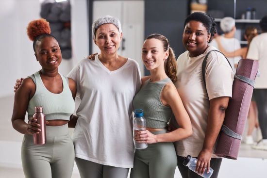 4 vrouwen staan gearmd op een rijtje na een fitness klasje